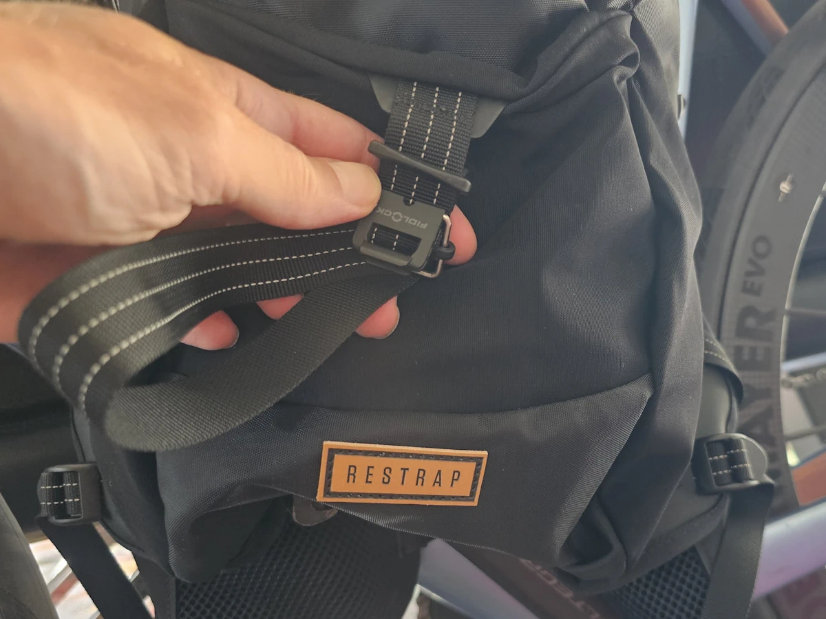 Detail van merklogo en strap sluiter op de Restrap Rolltop Hydration Vest