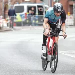 Trend van hardlopen naast wielrennen Peter fietsend tijdens de Ironman in Hamburg