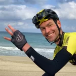 Beste fietshelm met communicatie Peter op strand met fietshelm